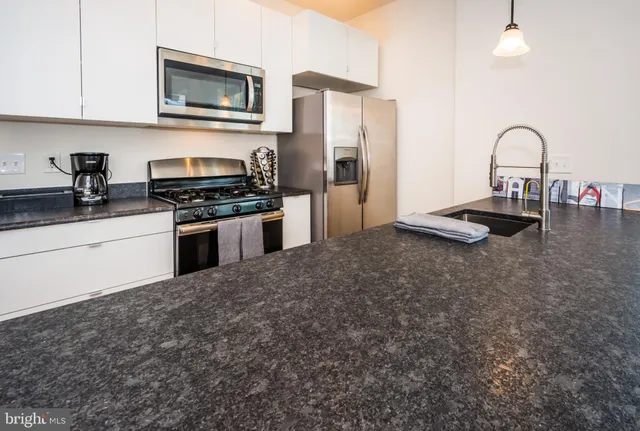 a kitchen with stainless steel appliances granite countertop a sink and a stove top oven