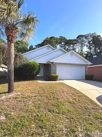a front view of house with yard and trees in the background