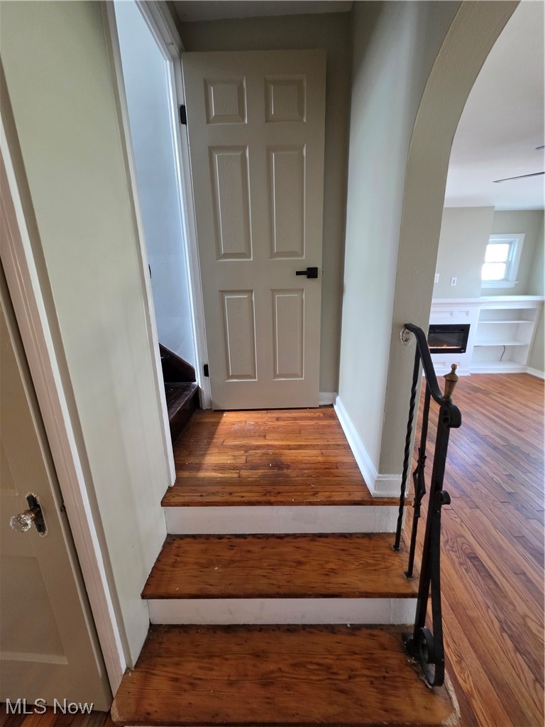 12813 North Road Cleveland, OH 44111 - Photo 15 of 30 Stairway with wood finished floors, arched walkways, and a glass covered fireplace