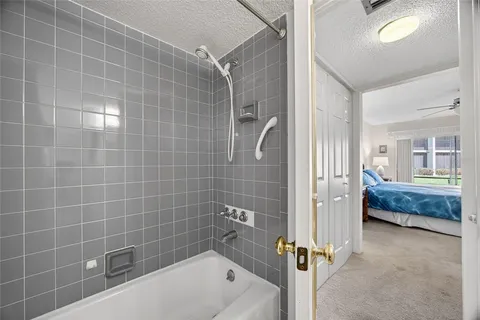 a bathroom with a tub a window and a glass door shower