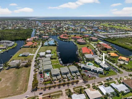 an aerial view of a city with lots of residential buildings ocean and mountain view in back