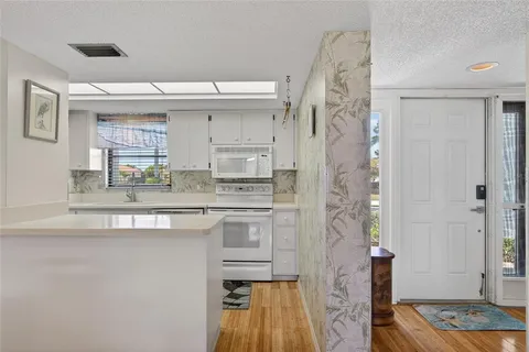 a kitchen with stainless steel appliances granite countertop a sink and a refrigerator