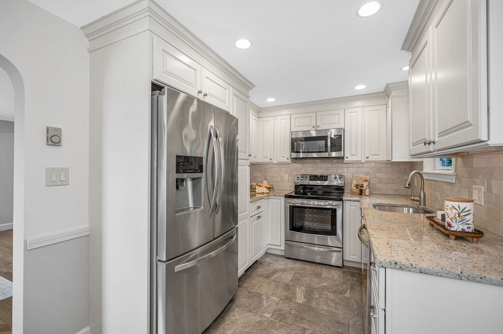 15 Eustis Avenue Wakefield, MA 01880 - Photo 7 of 42 a kitchen with stainless steel appliances granite countertop a refrigerator a stove a sink and a microwave