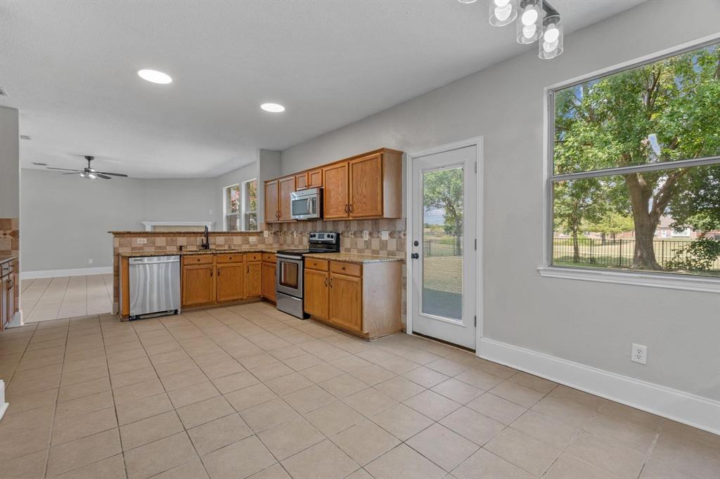 10618 Newcastleton Lane Rowlett, TX 75089 - Photo 3 of 13 a kitchen with stainless steel appliances granite countertop a stove a sink dishwasher and a refrigerator