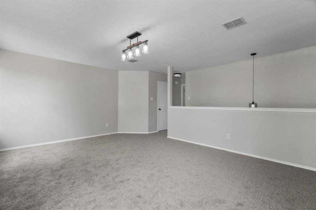 10618 Newcastleton Lane Rowlett, TX 75089 - Photo 9 of 13 a view of an empty room with a chandelier fan