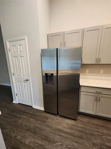 a kitchen with granite countertop a refrigerator and cabinets