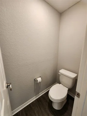 a white toilet sitting next to a white wall