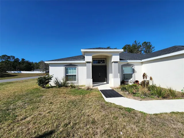 a view of a house with backyard and garden