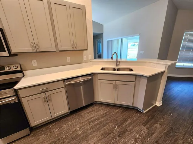 a kitchen with a sink cabinets and wooden floor