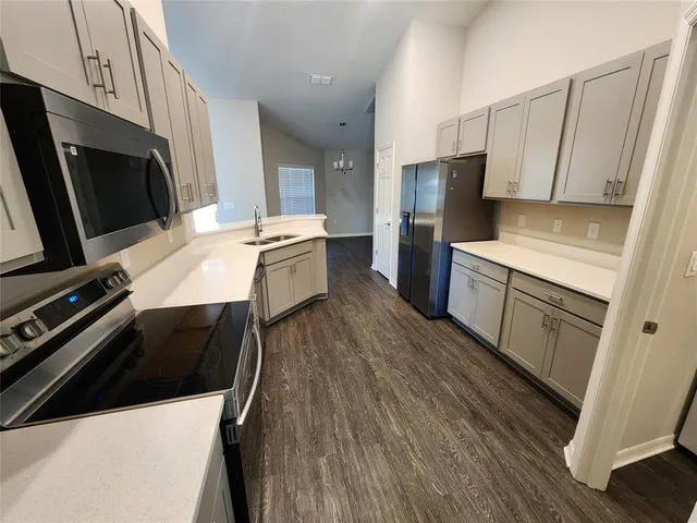 a kitchen with a sink a microwave a stove and refrigerator