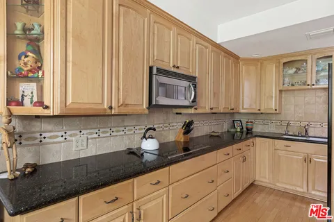 a kitchen with a refrigerator sink and cabinets