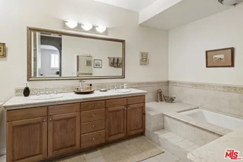 a bathroom with a tub sink and mirror