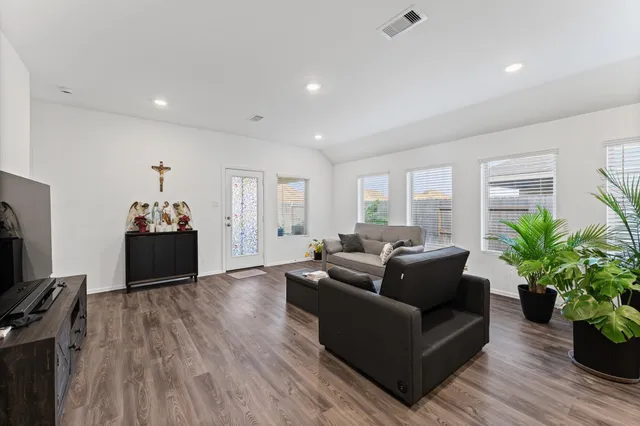 a living room with furniture potted plants and a flat screen tv