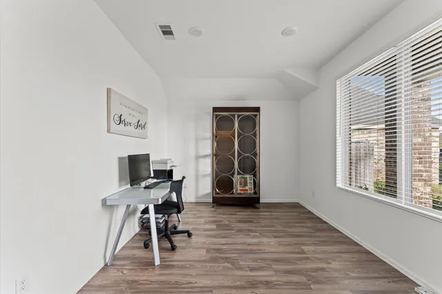 a view of a workspace with furniture and a window