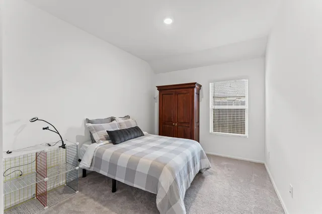 a bedroom with a bed and a window