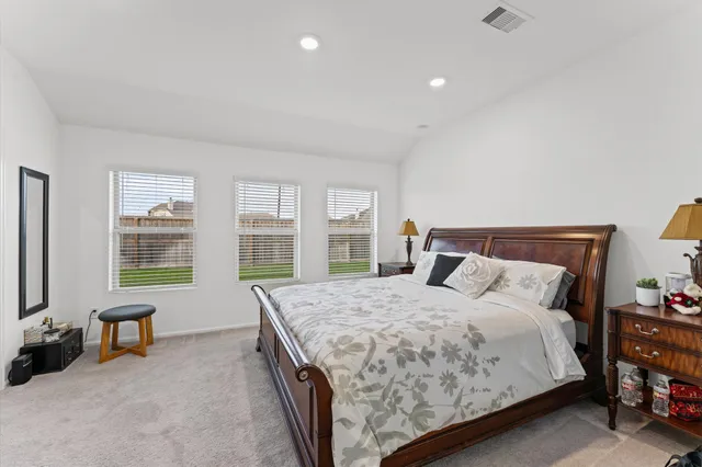 a bedroom with a bed and a dresser next to a window