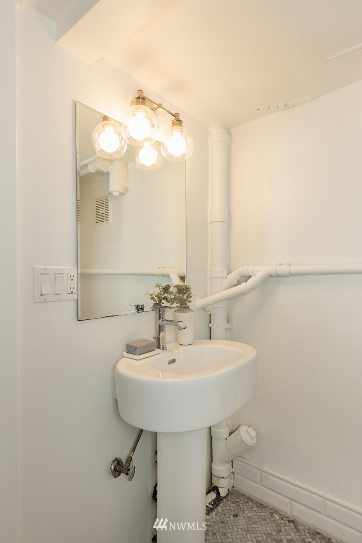 2409 30th Avenue West Seattle, WA 98199 - Photo 27 of 38 a bathroom with a sink a mirror and a toilet