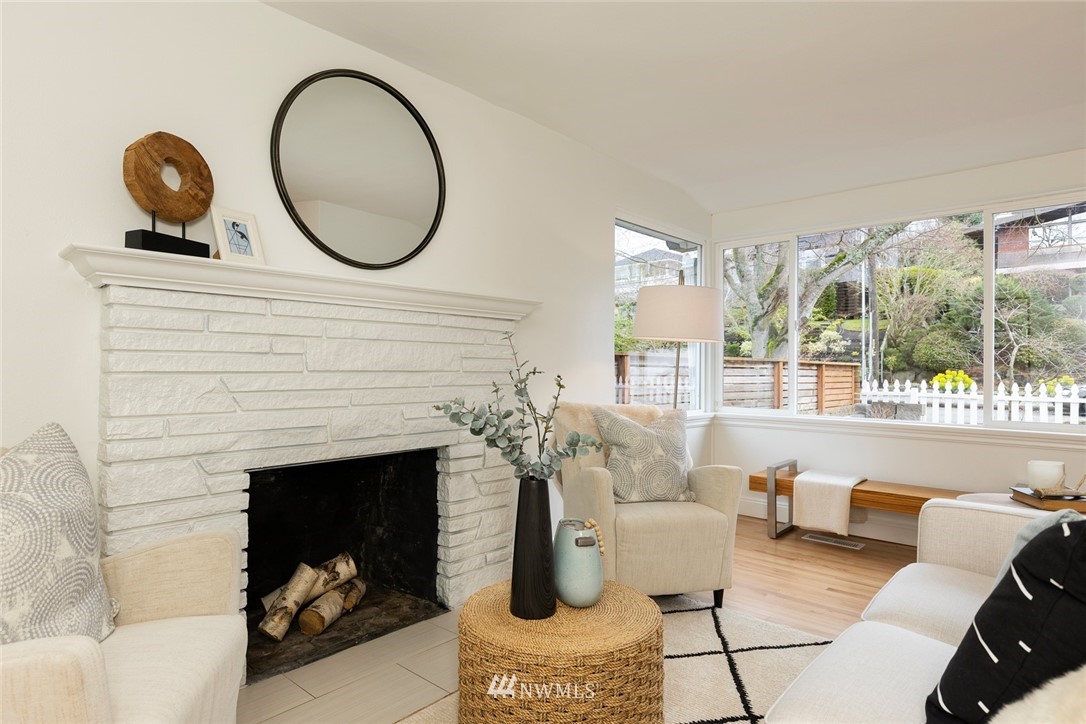 2409 30th Avenue West Seattle, WA 98199 - Photo 5 of 38 a living room with furniture a fireplace and potted plants
