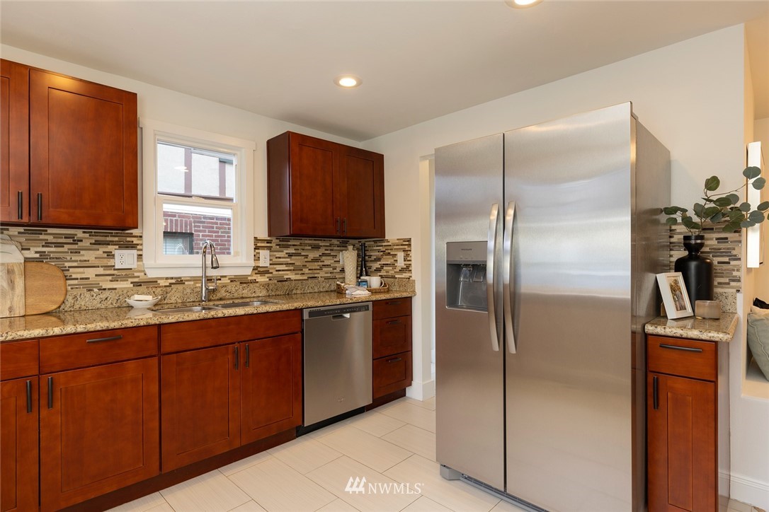 2409 30th Avenue West Seattle, WA 98199 - Photo 9 of 38 a kitchen with stainless steel appliances granite countertop a refrigerator and a sink