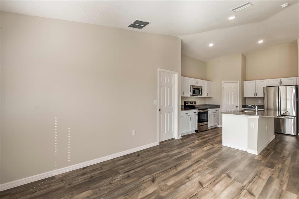 1338 Palmeroy Road Haines City, FL 33844 - Photo 13 of 32 a kitchen with white cabinets and stainless steel appliances