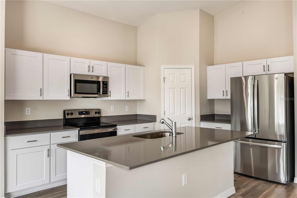 1338 Palmeroy Road Haines City, FL 33844 - Photo 5 of 32 a kitchen with a refrigerator stove and microwave