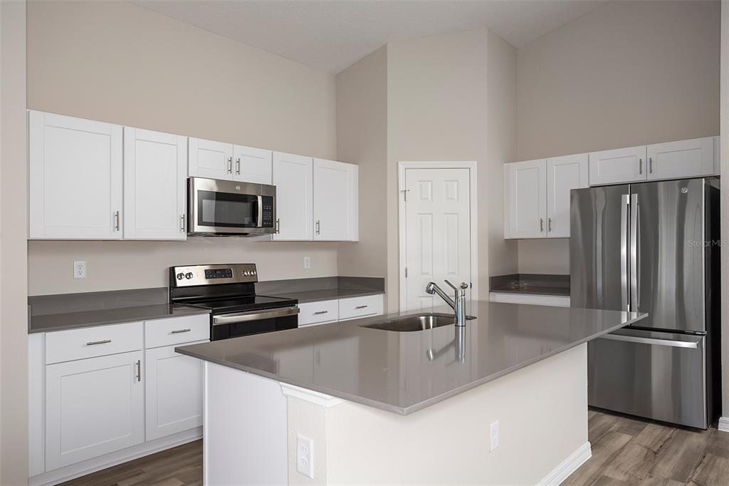 1338 Palmeroy Road Haines City, FL 33844 - Photo 7 of 32 a kitchen with stainless steel appliances granite countertop a sink a stove and a refrigerator