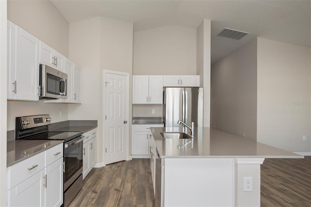 1338 Palmeroy Road Haines City, FL 33844 - Photo 8 of 32 a kitchen with stainless steel appliances a refrigerator sink and microwave