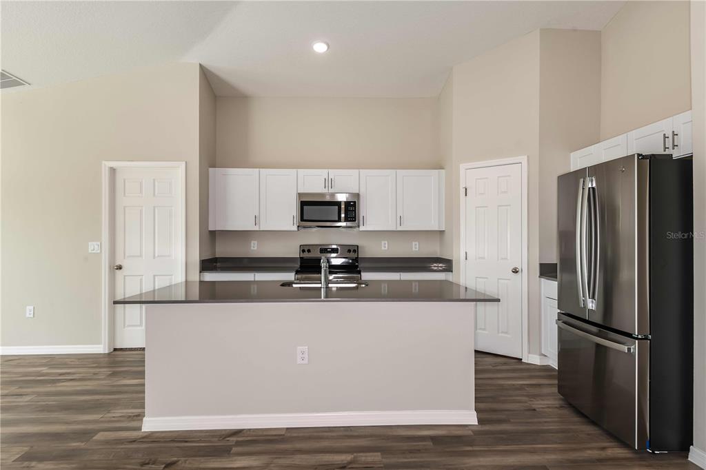 1338 Palmeroy Road Haines City, FL 33844 - Photo 10 of 32 a kitchen with stainless steel appliances granite countertop a refrigerator a stove and a wooden floors