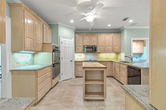 a kitchen with kitchen island granite countertop a stove a sink and a refrigerator