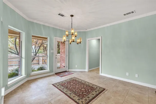 a view of a hallway with a chandelier and glass door