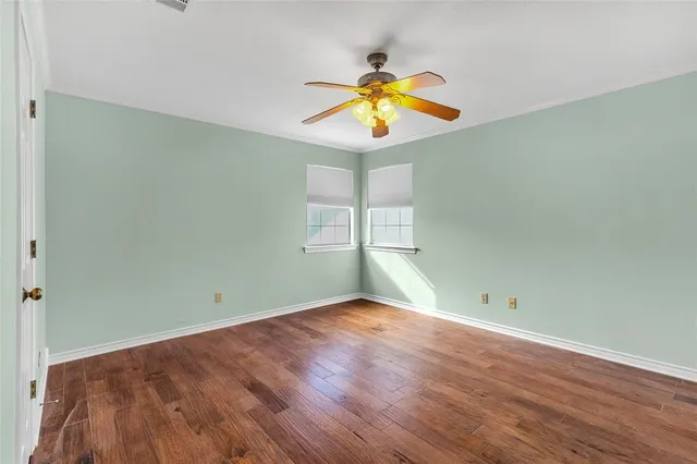 a view of a room with wooden floor and ceiling fan