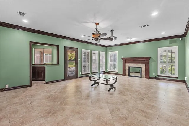 an empty room with furniture a fireplace and windows