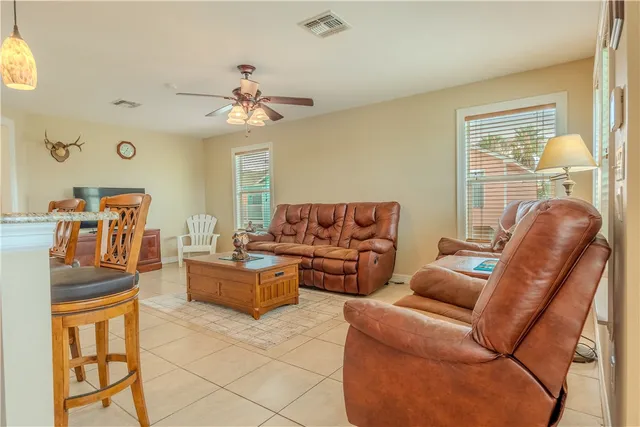 a living room with furniture a dining table and chairs with wooden floor