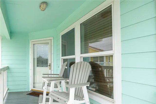 a view of balcony with two chairs and a large window