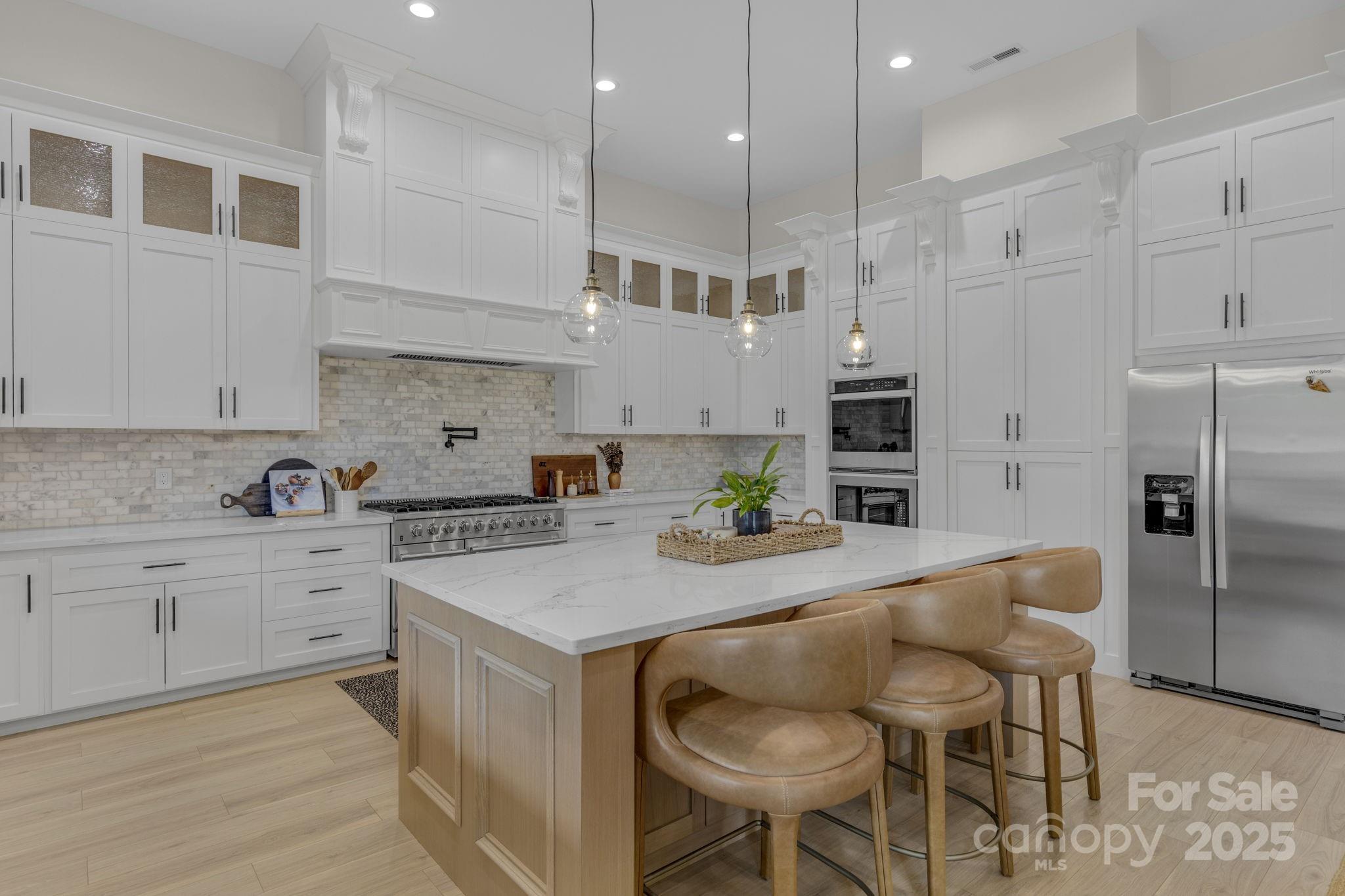 416 World Tour Drive Inman, SC 29349 - Photo 15 of 45 a kitchen with a refrigerator a stove a sink and white cabinets with wooden floor