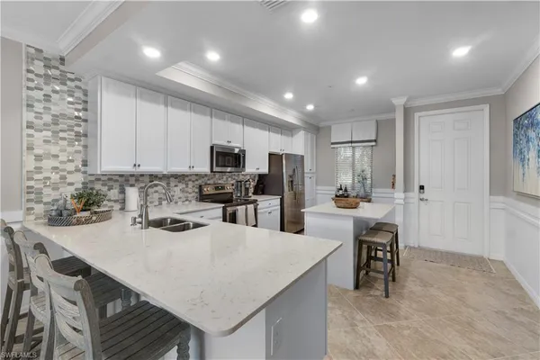 a kitchen with a sink a kitchen island and chairs