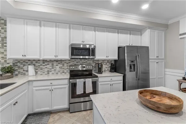 a kitchen with a sink a stove a refrigerator and cabinets