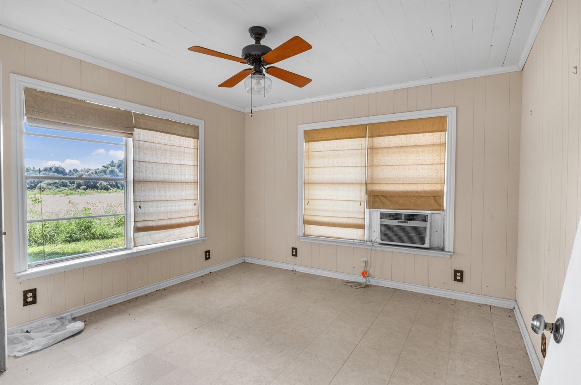 451 Pleasant Grove Road Elgin, TX 78621 - Photo 6 of 26 Empty room featuring baseboards, ceiling fan, ornamental molding, cooling unit, and tile patterned floors