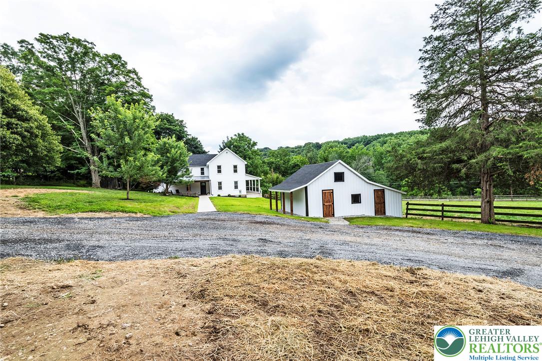 72 Allegheny Road Mount Bethel, PA 18343 - Photo 70 of 72 A classic white residence alongside a charming barn on a serene, tree-lined property.
