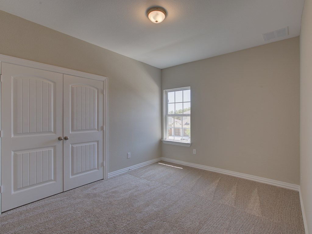 4303 Logan Ridge Drive Cedar Park, TX 78613 - Photo 13 of 24 Bedroom featuring neutral-toned walls, plush carpet flooring, and a multi-pane window