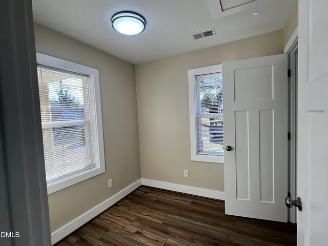 a large kitchen with wooden floors and stainless steel appliances