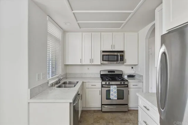 a kitchen with white cabinets and stainless steel appliances