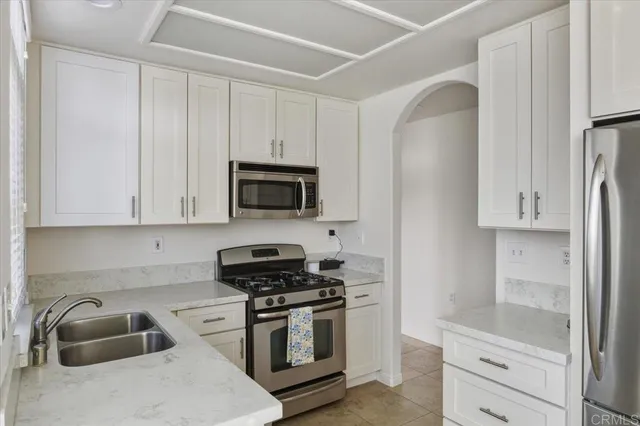 a kitchen with white cabinets and stainless steel appliances