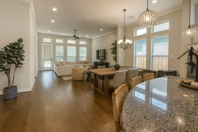 a living room with furniture a large window and a chandelier