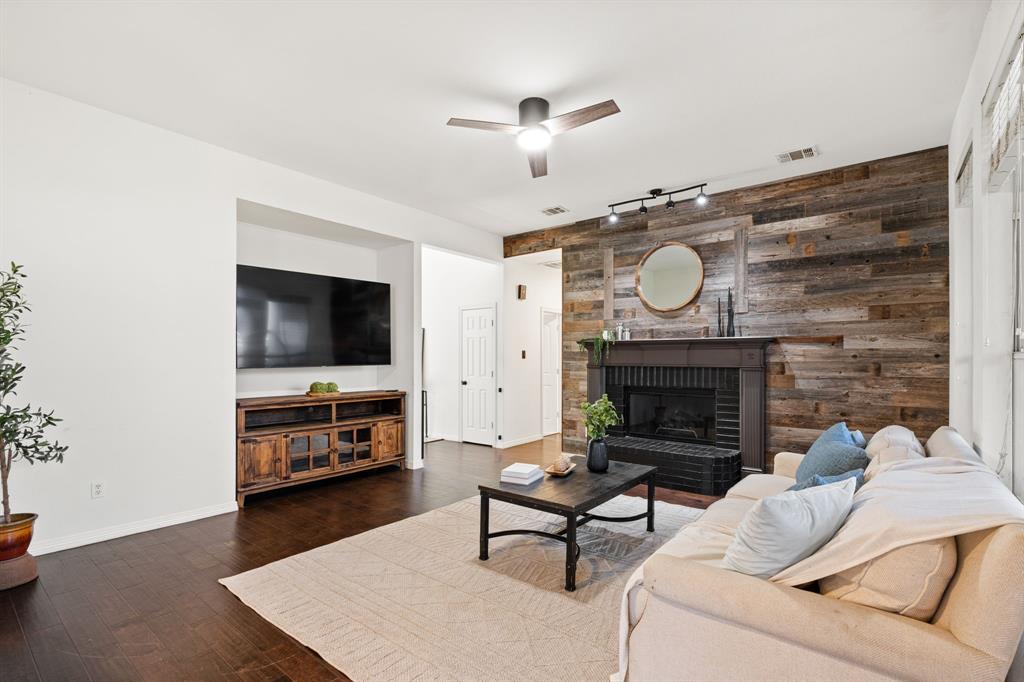3905 Lakeside Drive Rowlett, TX 75088 - Photo 25 of 39 Living area with wood walls, a ceiling fan, track lighting, dark wood-type flooring, and a fireplace