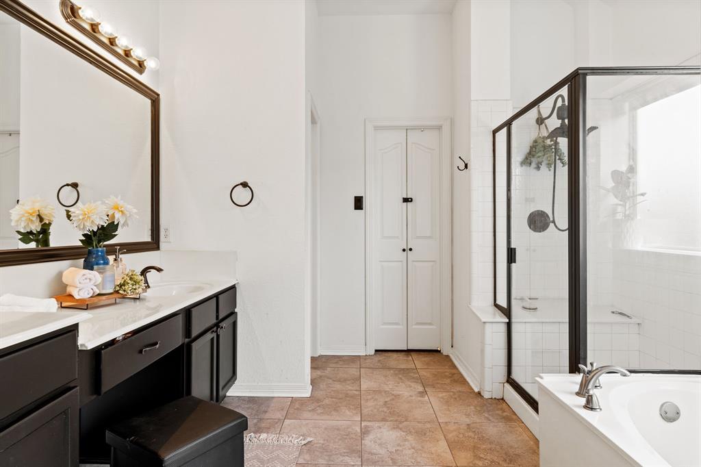 3905 Lakeside Drive Rowlett, TX 75088 - Photo 30 of 39 Full bathroom featuring double vanity, a shower stall, a bath, and light tile patterned floors