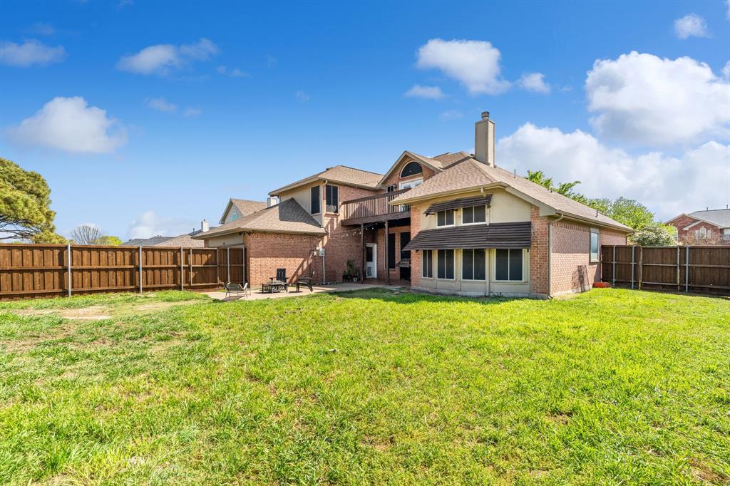 3905 Lakeside Drive Rowlett, TX 75088 - Photo 8 of 39 Back of house with brick siding, a chimney, a fenced backyard, a patio area, and roof with shingles