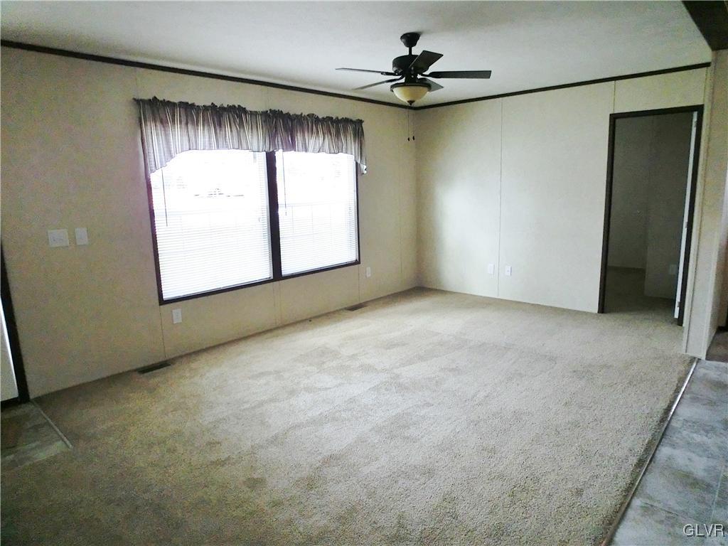 8871 Turkey Ridge Road Breinigsville, PA 18031 - Photo 3 of 8 an empty room with a window and a ceiling fan