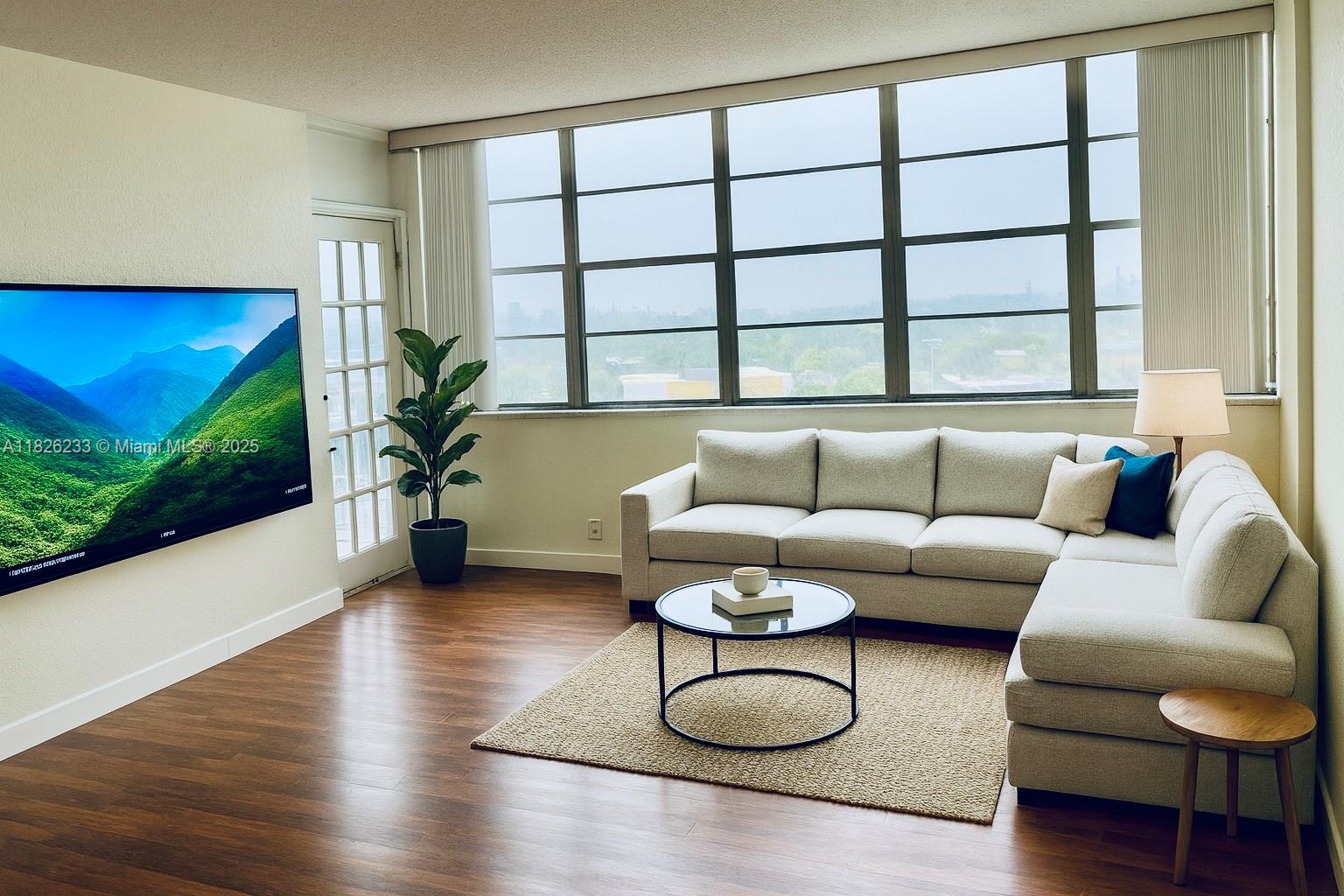 2025 Northeast 164th Street, Unit 901 North Miami Beach, FL 33162 - Photo 3 of 12 a living room with furniture and a large window
