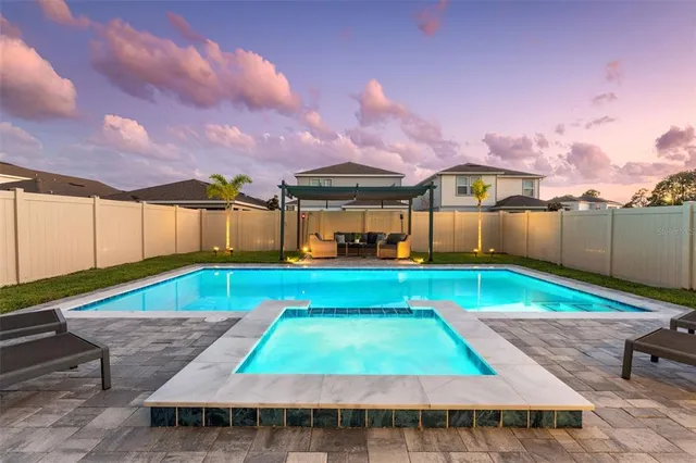 a view of a backyard with swimming pool and furniture